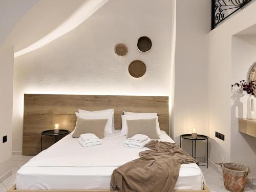 a bedroom with a large white bed with two tables at The Little House by the Sea in Stalida