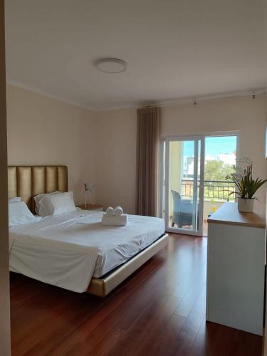 a bedroom with a large white bed and a balcony at O Pomar in Cabanas by Wave Algarve in Cabanas de Tavira