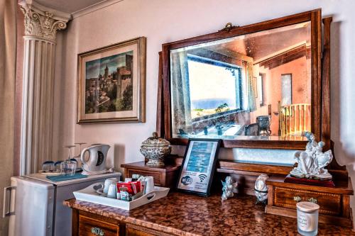a room with a table with a refrigerator and a mirror at B&B Villa Bency in Capo dʼOrlando