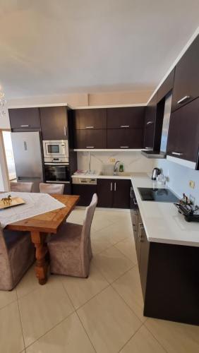 eine Küche mit einem Holztisch und einer Arbeitsplatte in der Unterkunft Daniel Apartment 2 in Sarandë