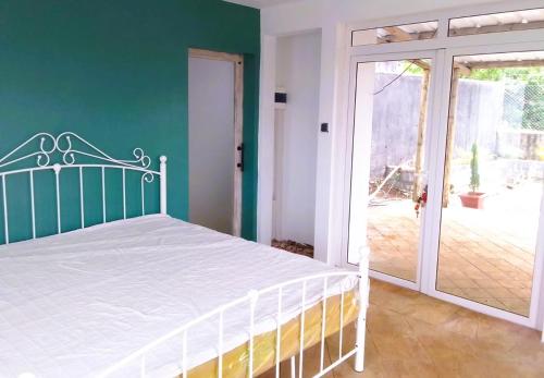 a bedroom with a white bed and a sliding glass door at Mountain Lodge in La Laura