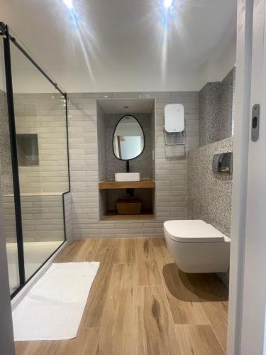 une salle de bain avec toilettes, lavabo et miroir dans l'établissement Petite maison de village, à Bastelica