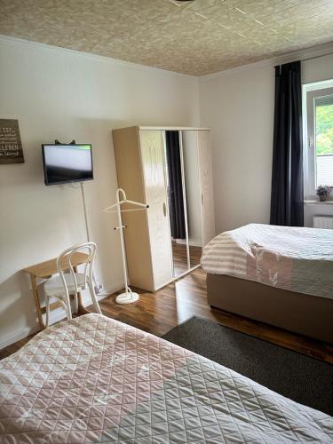 a hotel room with two beds and a television at Ferienhaus nähe Lamspringe mit 5 Schlafzimmer in Winzenburg