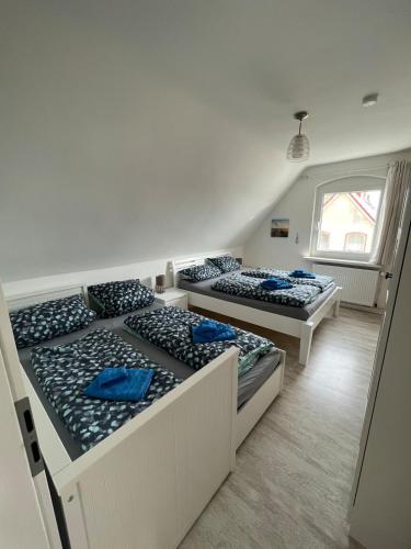 a room with three beds with blue pillows on them at Ferienhaus Jastoria in Sassnitz
