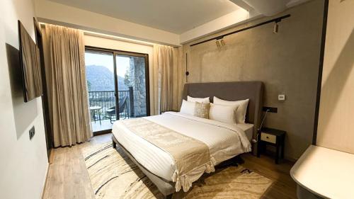 a bedroom with a bed and a large window at Checkmate in Mussoorie