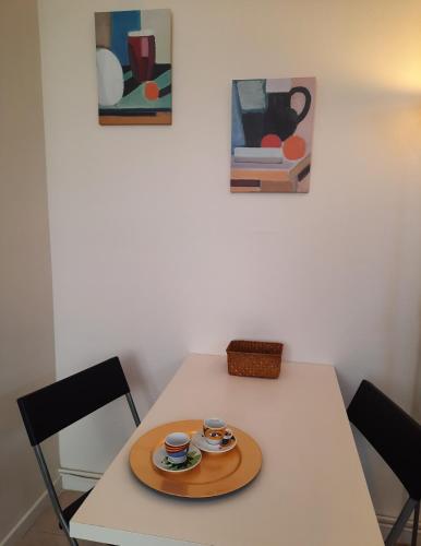 une table avec deux tasses et une assiette sur elle dans l'établissement Les Mouettes, au Havre