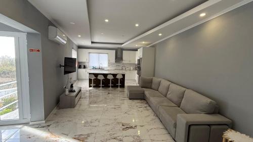 a living room with a couch and a kitchen at Amazing Home in Ponta Garça