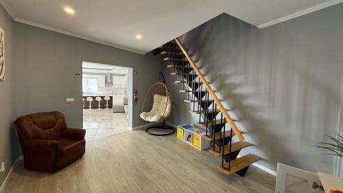 a living room with a staircase and a chair at Amazing Home in Ponta Garça