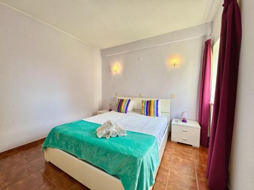 a small bedroom with a bed with a blue blanket at Vilamoura Central 10 by Homing in Vilamoura