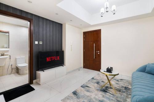 a living room with a couch and a tv and a bathroom at Super Deluxe Apartmentpool in Dubai
