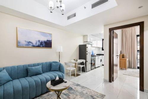 a living room with a blue couch and a kitchen at Super Deluxe Apartmentpool in Dubai