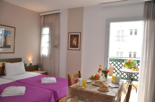a bedroom with a bed and a table with food on it at Helen Suites in Limín Khersonísou