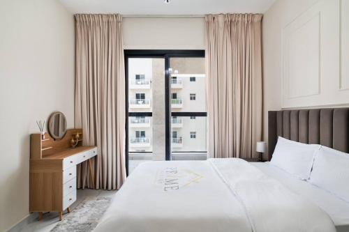 a bedroom with a bed and a desk and a window at Super Deluxe Apartmentpool in Dubai