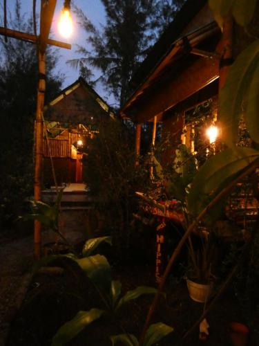 a house lit up at night with a street light at Uncle Hippie's Dream in Gili Meno