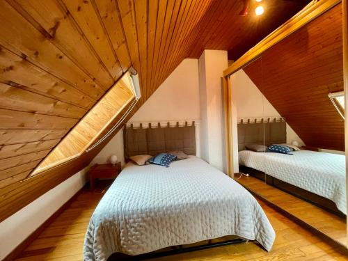 une chambre avec deux lits dans un grenier dans l'établissement Maison d'exception avec étang privé en chartreuse, à Saint-Pancrasse