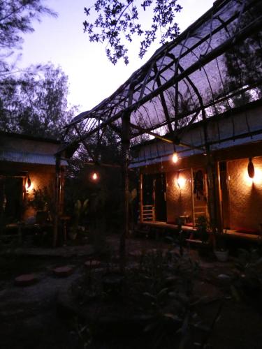 a building with a lit up roof at night at Uncle Hippie's Dream in Gili Meno