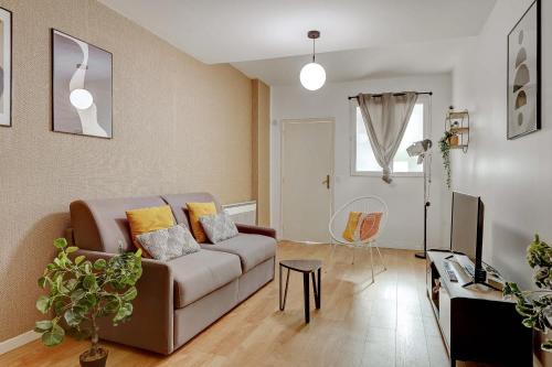 un salon avec un canapé et une table dans l'établissement Appartement raffine proche Parc de la Villette - 4P, à Paris