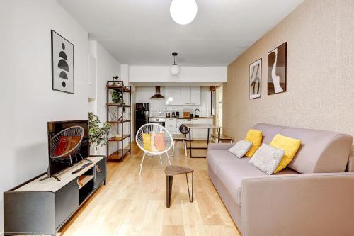 un salon avec un canapé et une cuisine dans l'établissement Appartement raffine proche Parc de la Villette - 4P, à Paris