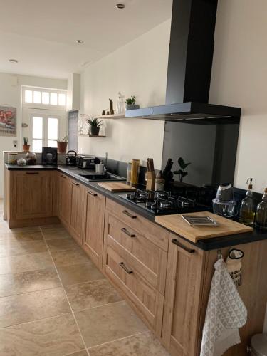 - une cuisine avec des placards en bois et une cuisinière dans l'établissement Maison de ville au bord des berges du Tarn, à Albi