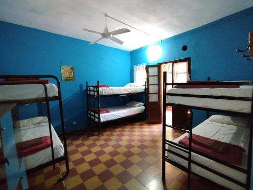a room with four bunk beds and a ceiling fan at Andamundos Hostel in Mina Clavero