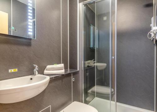Un baño con inodoro, lavabo y ducha. en Apartment with Access to Pool Spa & Soft play, en Ilfracombe