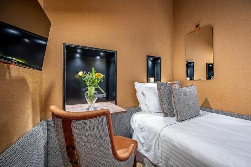 a hotel room with a bed and a vase of flowers at Hotel Duomo Firenze in Florence
