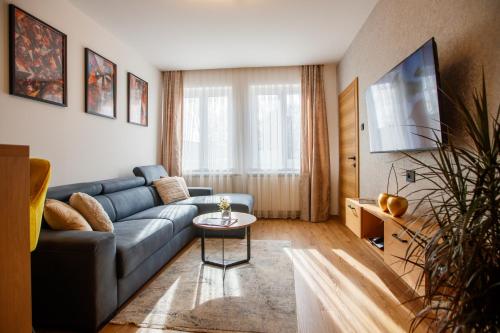 a living room with a blue couch and a table at Garni Hotel Royal Crown in Subotica