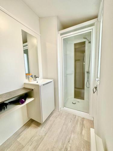 une salle de bain blanche avec un lavabo et une douche dans l'établissement Bungalow 3 chambres pour 6 pers avec Climatisation Camping 3 etoiles, à Samoëns