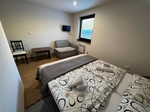 a bedroom with a bed and a chair and a window at Penzion u Studánky in Horní Věstonice