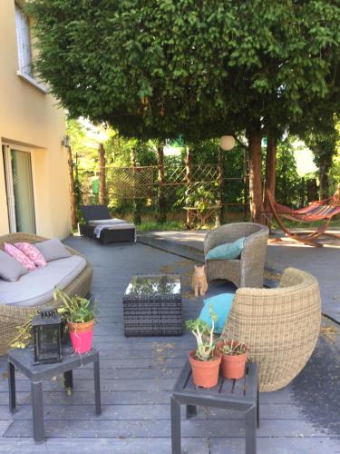 a patio with couches and chairs and potted plants at Vacances révées au Pin Parasol in Le Thor