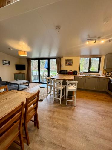 a large kitchen with a wooden table and chairs at Riverside Cabins in Shrewsbury