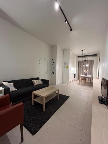 Una sala de estar con un sofá y una mesa de café. en Studio Tzawel, en Gante
