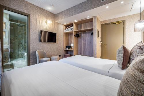 a hotel room with two beds and a tv at Hotel Duomo Firenze in Florence