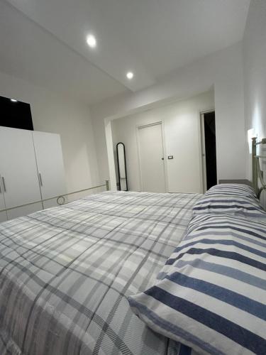a bedroom with a large bed with a striped blanket at Magic Dream , Bari in Bari