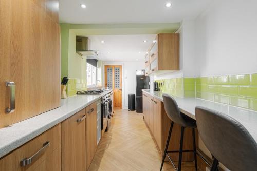 a kitchen with wooden cabinets and green walls at 10 Min to Beach Cheap Taxi to City FreeParking in Liverpool