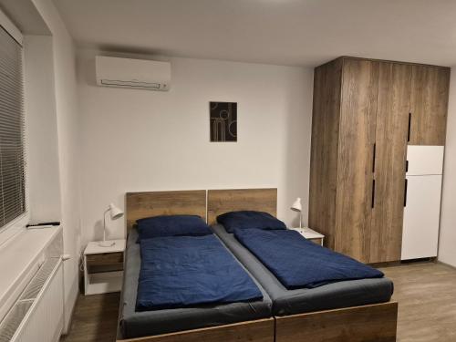 a bedroom with a bed with blue pillows on it at SK Apartments in Prešov