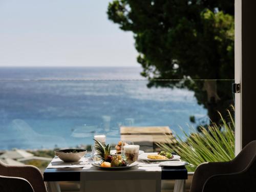 a table with food on it with a view of the ocean at Esperos Village Blue & Spa - Adults Only in Faliraki