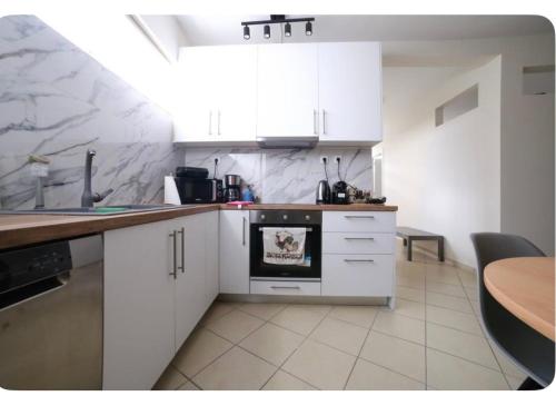 a kitchen with white cabinets and a counter top at Home4U apt1, just 8Km from airport in Markopoulo