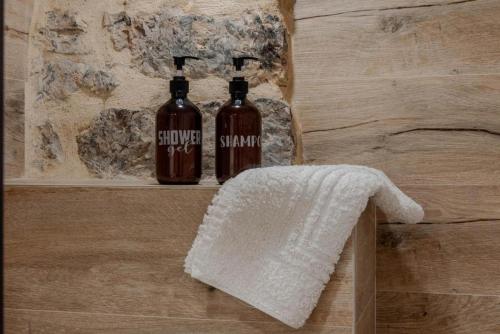 deux bouteilles d'alcool posées sur une étagère dans une salle de bain dans l'établissement El Patio de Vespasiano-Calera- vistas a la iglesia junto al puerto, à Castro Urdiales