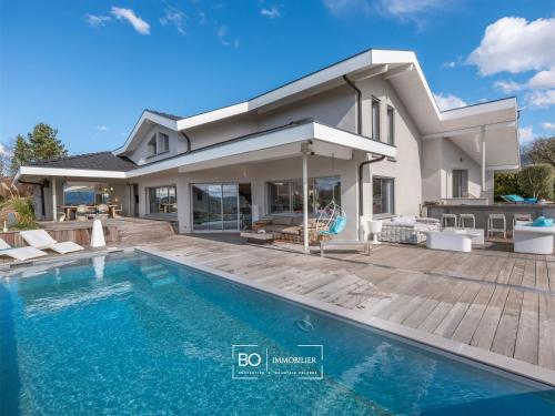 une maison avec une piscine devant une maison dans l'établissement Villa View - Annecy Lake, à Balmont