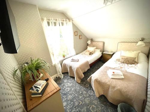 a hotel room with two beds and a window at Rosebank House Bed & Breakfast in Strathyre