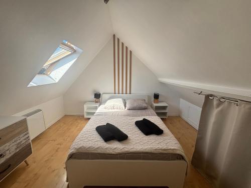 a bedroom with a bed with two pillows on it at Cosy Duplex ! Situation centrale - proche plage et commerces - linge de lit et serviettes de toilette compris in Ouistreham