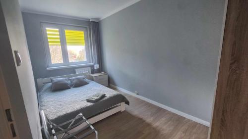 a small bedroom with a bed and a window at Apartament Modlin in Nowy Dwór Mazowiecki