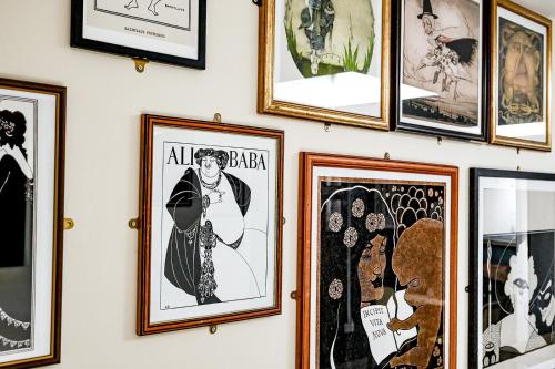 a wall of framed pictures on a wall at 82A Dalston Lane Terrace in London