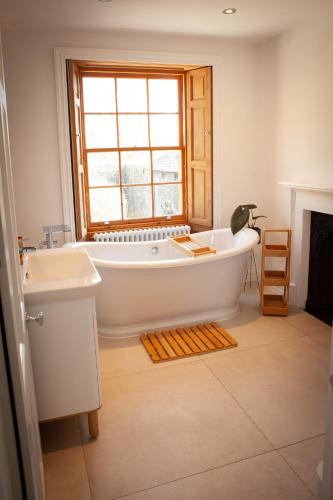 a bathroom with a tub and a sink and a window at Starbright Cottage in Peebles
