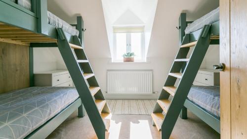 two bunk beds in a room with a window at Swn y Mor Trefadog in Llanfaethlu