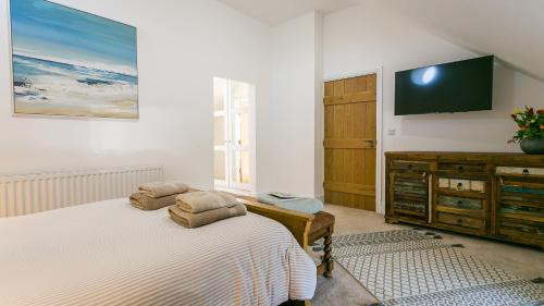 a bedroom with a bed and a flat screen tv at Swn y Mor Trefadog in Llanfaethlu