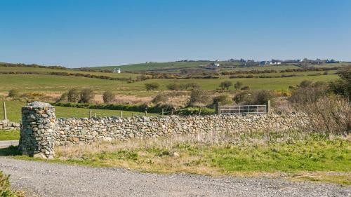 a stone wall on the side of a road at Swn y Mor Trefadog in Llanfaethlu