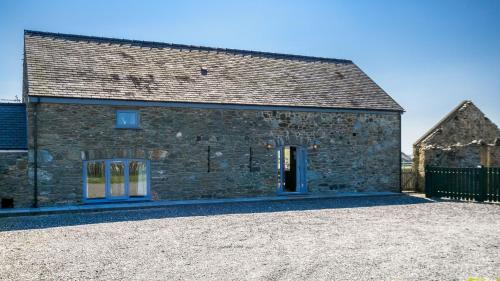 an old stone house on a gravel road at Swn y Mor Trefadog in Llanfaethlu