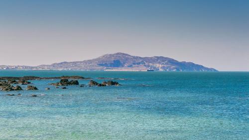 a large body of water with a mountain in the background at Swn y Mor Trefadog in Llanfaethlu